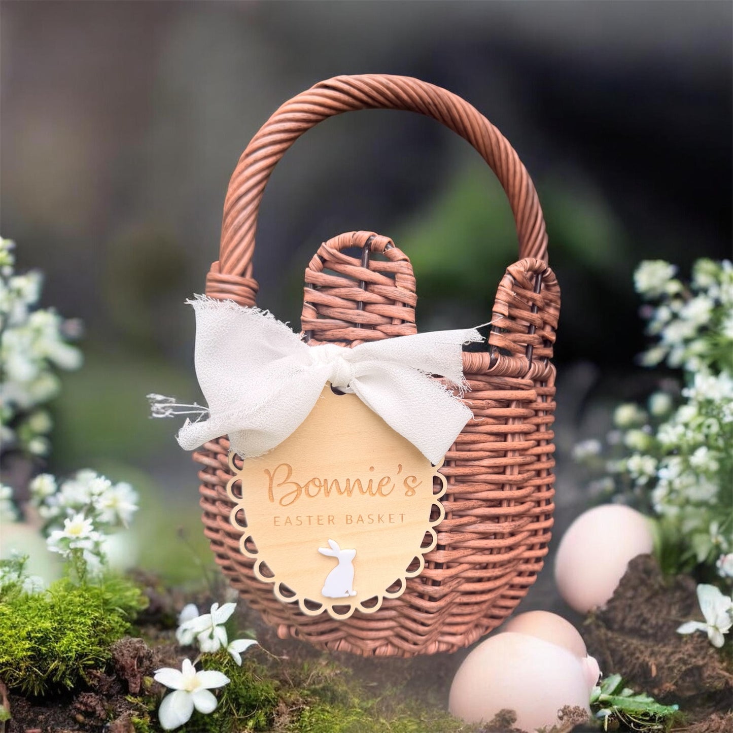 Personalised Easter basket tag with fabric bow in white or blush pink, scalloped wooden bunny name plaque attached to woven basket.