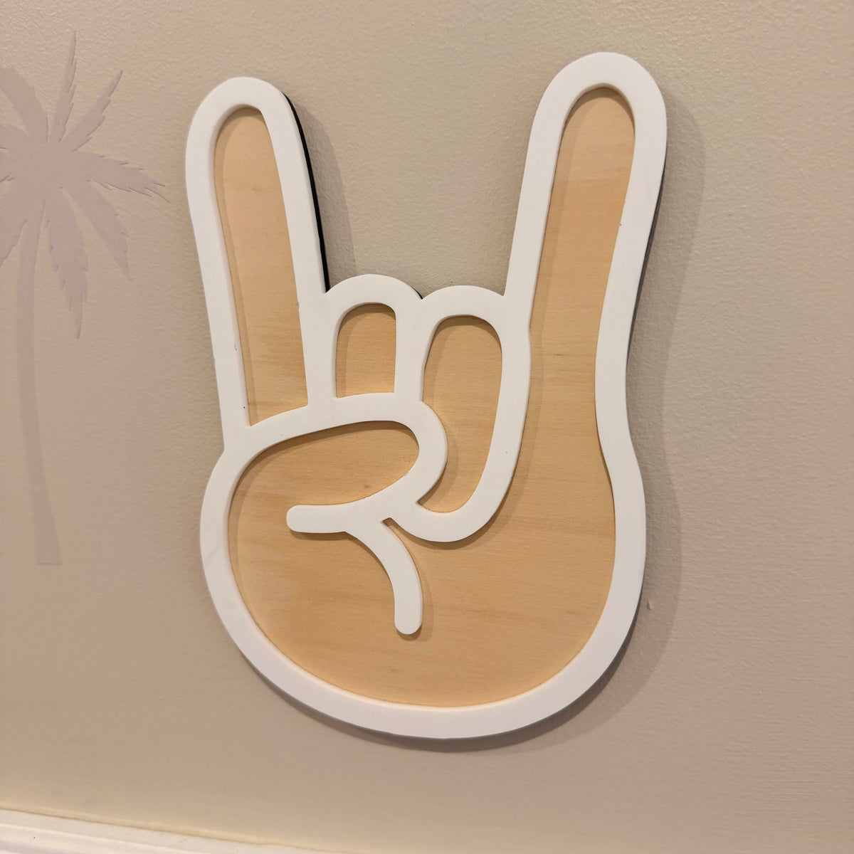 Wooden rock on hand sign hanging on beige wall