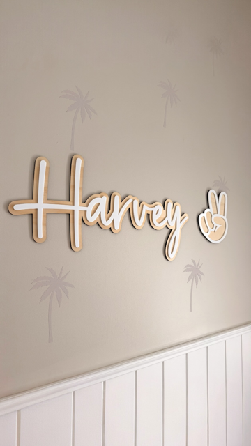 Wooden Personalised name sign with Harvey written in white acrylic hanging on a beige wall
