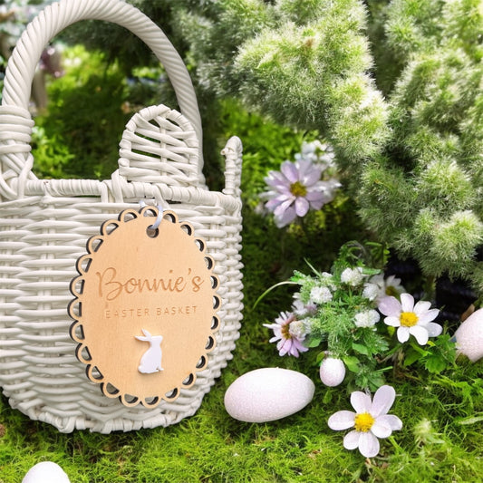 Personalised Easter basket tag with scalloped edge and white bunny detail attached to woven basket, custom wooden Easter name plaque for kids.