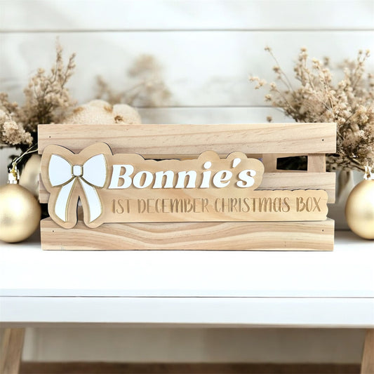 wooden crate with personalised name plaque with bow for christmas, that states 1st December or Christmas eve box