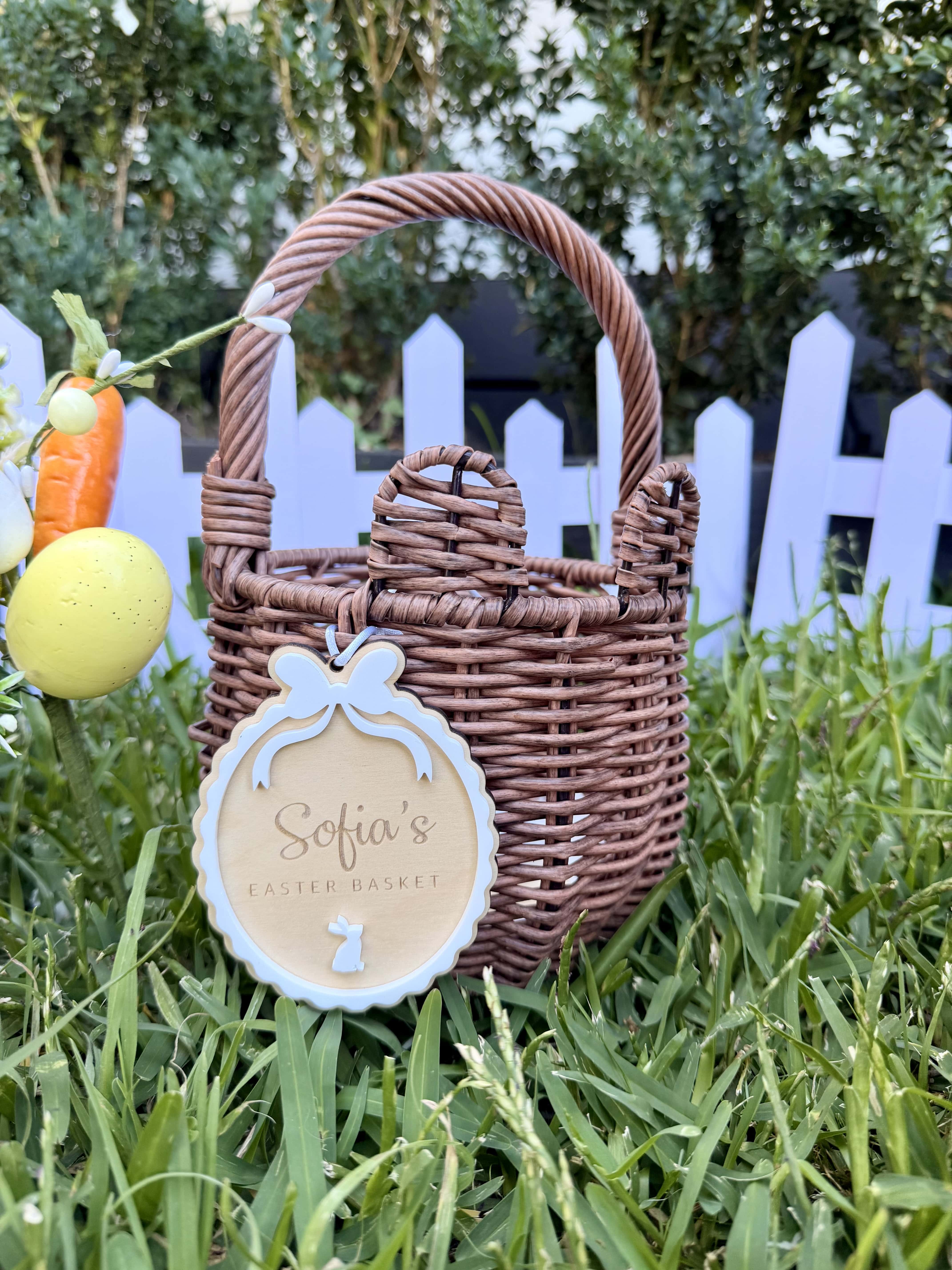 Engraved name on oval Easter basket tag with white scalloped border and white bunny.
