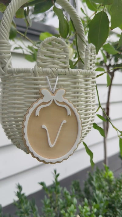 Video of an Easter Tag with white bow and the letter V and it turns over into my First Easter hanging from white basket